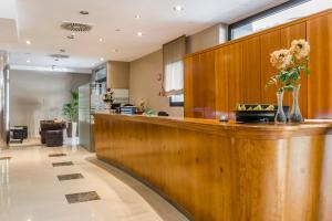 a lobby with a bar with flowers on it at Hotel Civera in Teruel