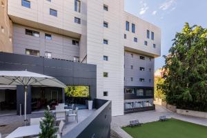 an external view of a building with a table and chairs at Hotel Civera in Teruel