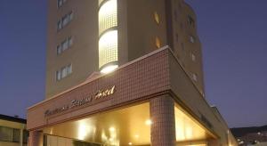 Un edificio con un cartel en el frente. en Kamisuwa Station Hotel, en Suwa