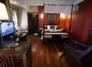 Habitación con 1 dormitorio con 1 cama y TV. en Anggun Boutique Hotel, en Kuala Lumpur