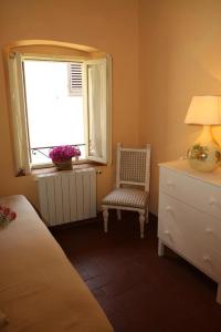 a bedroom with a bed and a window and a chair at Affittacamere Gir di Mura in Montecatini Terme