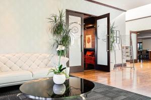 a living room with a couch and a table with plants at Hotel Elms Christchurch, an Ascend Collection Hotel in Christchurch