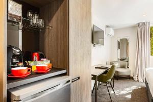 a kitchen with red bowls on a counter in a room at Hotel Elms Christchurch, an Ascend Collection Hotel in Christchurch