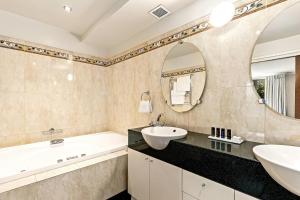 a bathroom with a tub and a sink and a mirror at Hotel Elms Christchurch, an Ascend Collection Hotel in Christchurch +78 photos