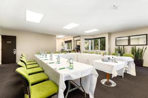 a conference room with white tables and green chairs at Hotel Elms Christchurch, an Ascend Collection Hotel in Christchurch