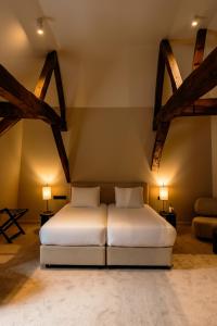a bedroom with a bed in a room with beams at Hôtel Royal Beaulaincourt in Béthune +22 photos