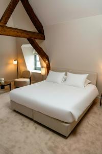 a bedroom with a large white bed in a room at Hôtel Royal Beaulaincourt in Béthune