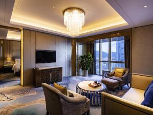 a living room with a television and a couch at Pullman Yantai Center in Yantai