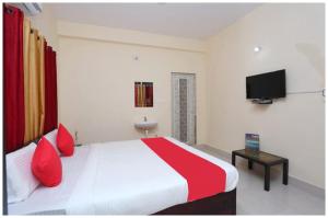 a bedroom with a bed with red pillows and a tv at Hotel Moonlight Palace Near Patia Railway Station-Fully Air Conditioning Hotel - Luxury & Spacious Room -A Premium Hotel in Cuttack