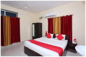 a bedroom with a large bed with red curtains at Hotel Moonlight Palace Near Patia Railway Station-Fully Air Conditioning Hotel - Luxury & Spacious Room -A Premium Hotel in Cuttack +9 photos