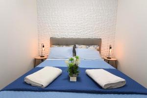 a bedroom with a blue bed with two pillows at Terra Sinus Luxury apartment in Terrasini