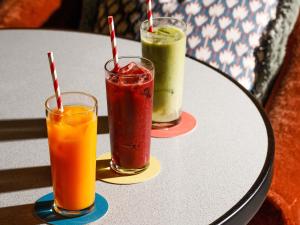 three drinks are sitting on a table at TRIBE London Canary Wharf in London