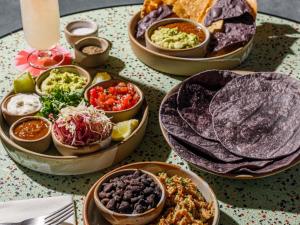 a table topped with bowls of different types of food at TRIBE London Canary Wharf in London