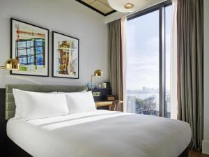 a bedroom with a large bed and a large window at TRIBE London Canary Wharf in London +103 photos