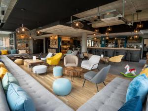 a living room with couches and chairs and tables at Greet Hôtel Orthez Bearn in Orthez