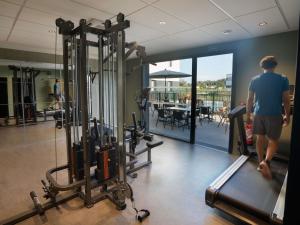 a man is walking in a gym with a treadmill at Greet Hôtel Orthez Bearn in Orthez +66 photos