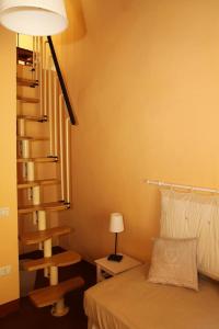 モンテカティーニ・テルメにあるAffittacamere Gir di Muraのベッドルーム1室(ベッド1台付)、螺旋階段