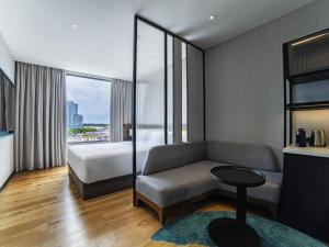 a hotel room with a bed and a couch at Mercure Miri City Centre in Miri +57 photos