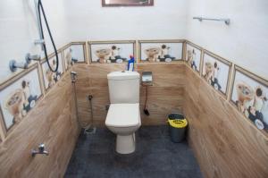 a bathroom with a toilet in a room with pictures on the wall at Apartment Room - Mathara in Matara