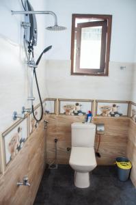 a bathroom with a toilet and a shower with a window at Apartment Room - Mathara in Matara