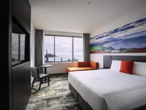a hotel room with a bed and a large window at Novotel Devonport in Devonport