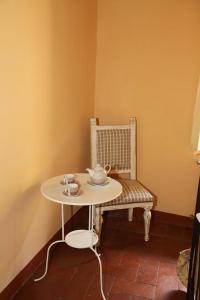a small table and a bench with a tea set on it at Affittacamere Gir di Mura in Montecatini Terme