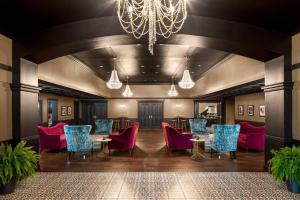 a large room with tables and chairs and a chandelier at The Highlander Hotel, Ascend Hotel Collection in Iowa City