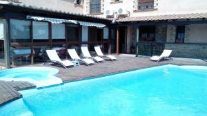 a swimming pool with lounge chairs next to a building at Hotel Rural Los Abriles in El Toro