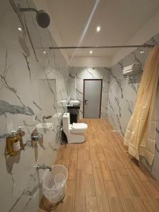 a bathroom with a stone wall with a shower and a toilet at Triviera Hotel Chirala in Chīrāla