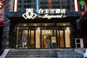 un frente de tienda con un árbol de Navidad delante de él en Magnotel Shenyang Consulate Qingnian Street, en Shenyang