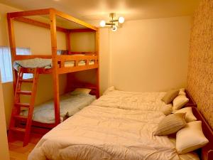 a bedroom with two bunk beds and a ladder at Fuji AK Vacation Rental in Fujiyoshida