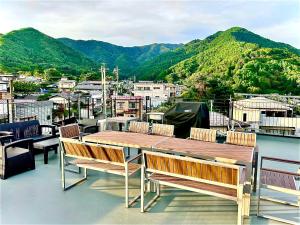 a table and chairs on a balcony with mountains at Fuji AK Vacation Rental in Fujiyoshida