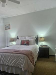 a bedroom with a large bed with two lamps at Sharing is Caring in Mahikeng