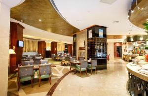 a restaurant with tables and chairs and a bar at The Pavilion Hotel in Shenzhen