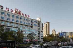 a large building with a sign on top of it at Magnotel Classic Shenyang General Hospital of Northern Theater Command in Shenyang
