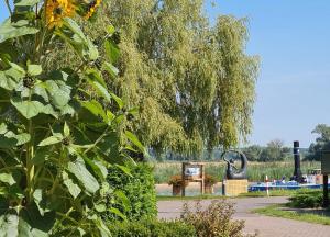 a weeping willow tree and a bench in a park at Ferienwohnung Havelnixe in Bahnitz