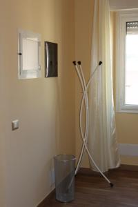 een metalen voorwerp in de hoek van een kamer met een raam bij Mille Charme and Relais in Sassari