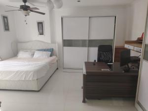 a bedroom with a bed and a desk with a computer at One Bedroom Condominium at Kandi Tower 2 in Angeles