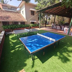 Una mesa de ping pong en un patio con dos mesas. en Nisarga Resort, en Kaglipur