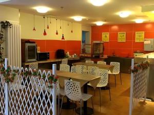 a dining room with tables and chairs and red walls at 7 Days Inn Nanjing Xinjiekou Changfu Street Metro Station in Nanjing