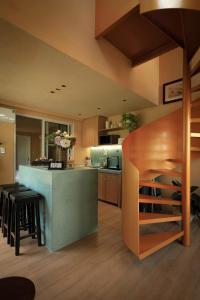 a kitchen with a bar with stools in a room at Amya home Hoi An in Hoi An