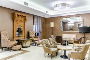 vestíbulo con sillas, mesas y espejo en Hotel Reina Cristina, en Teruel