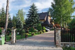 a fence in front of a house with a driveway at Willa Krystyna in Kościelisko