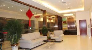 a lobby with two white couches in a building at GreenTree Alliance Yichang East Yichang Station Hotel in Yichang