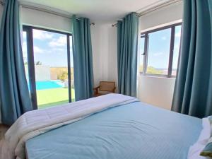 Un dormitorio con cortinas azules y una cama y una ventana. en Villa Esperenza-3 bedrooms, en Flic en Flac 42 fotos más