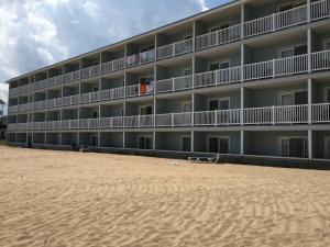 um hotel na praia com uma praia de areia em Fairview Beachfront Inn em Mackinaw City