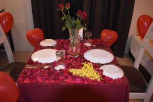 a table with red hearts and flowers on it at Sun City Resort in Calangute +291 photos