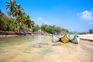 three boats sitting in the water on a beach at Sun City Resort in Calangute