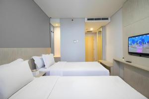 ジョグジャカルタにあるMIC Residenceのベッド2台と薄型テレビ付きのホテルの部屋