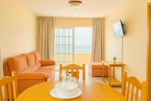 a living room with a table and a couch at Be six Playa La Arena in Puerto de Santiago